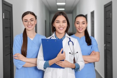 Photo of Team of professional doctors in clinic hallway