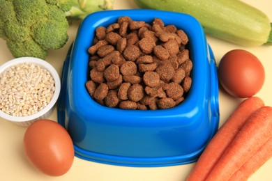 Dry pet food and products on beige background, closeup