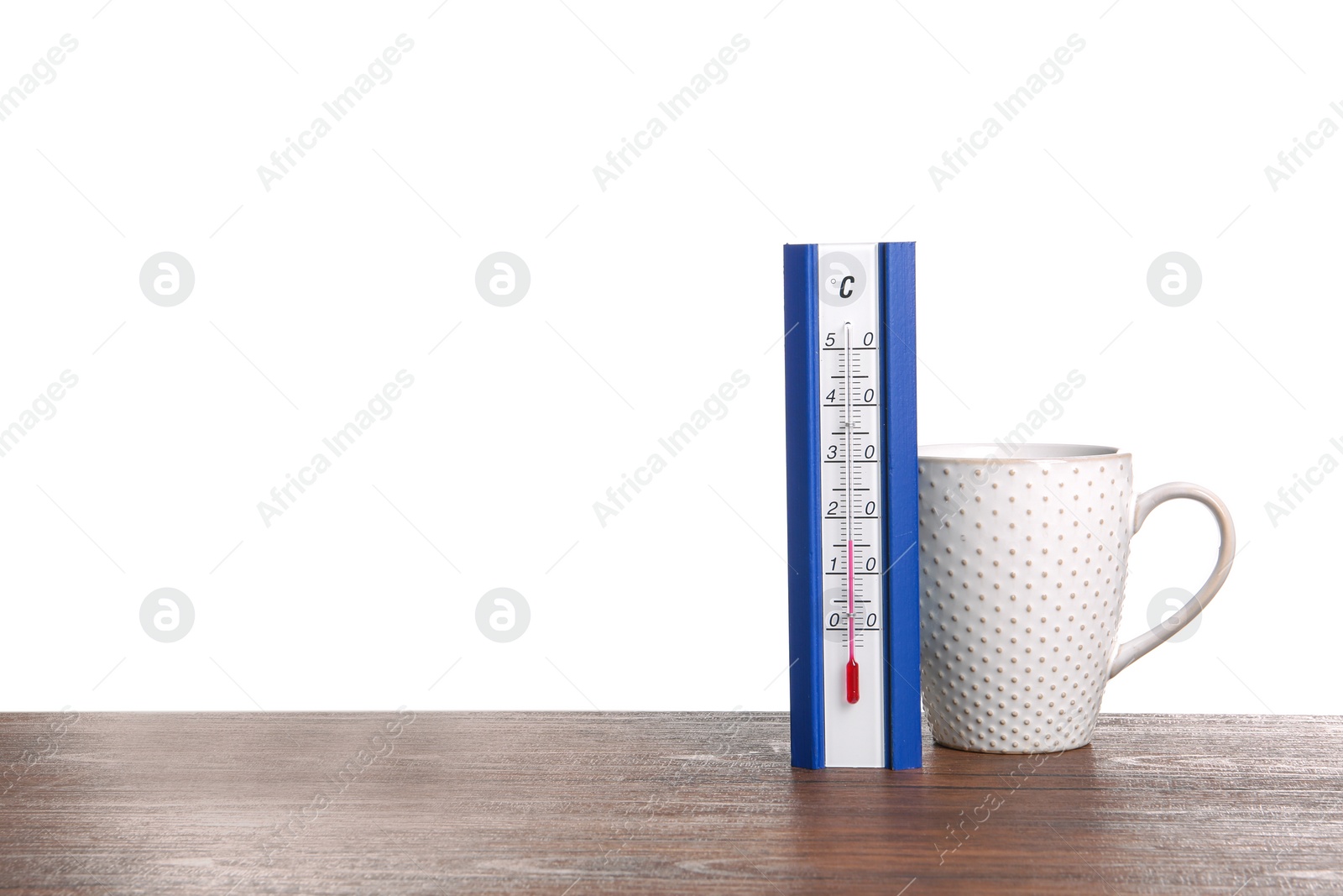 Photo of Thermometer and cup of hot tea on wooden table against white background. Space for text