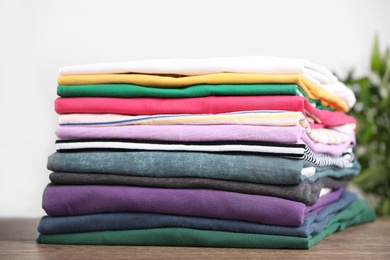 Photo of Pile of ironed clothes on table, closeup