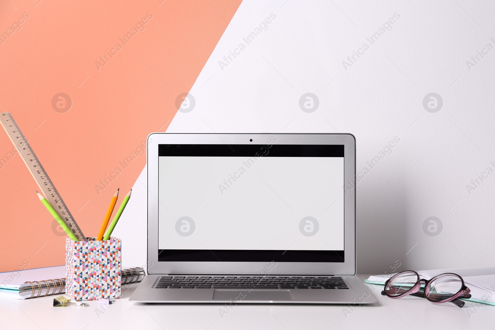 Photo of Modern laptop and stationery on table in office