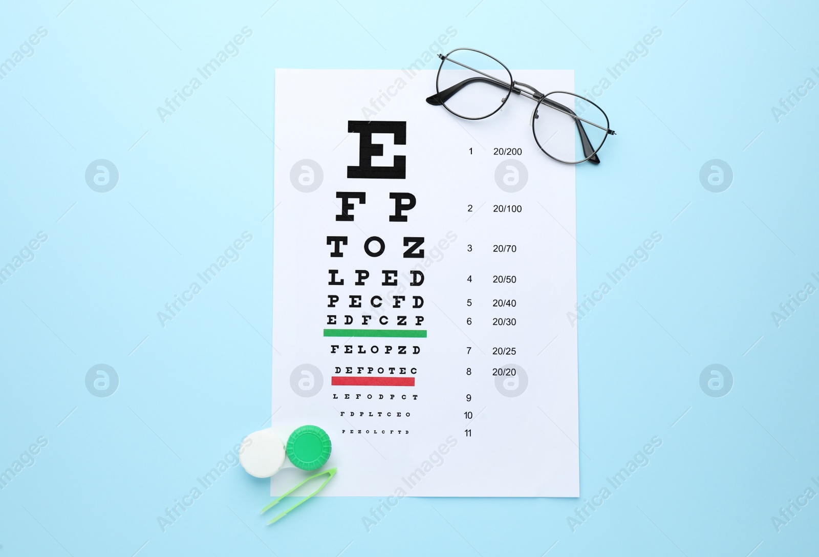 Photo of Case with contact lenses, tweezers, glasses and eye chart test on light blue background, flat lay