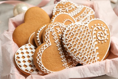 Photo of Tasty heart shaped gingerbread cookies in box, closeup