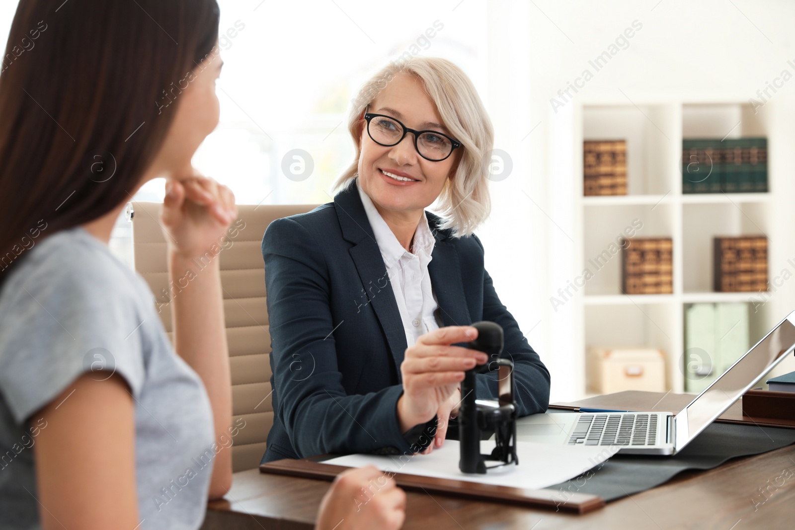 Photo of Female notary working with client in office