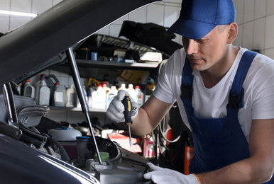 Professional auto mechanic fixing modern car in service center