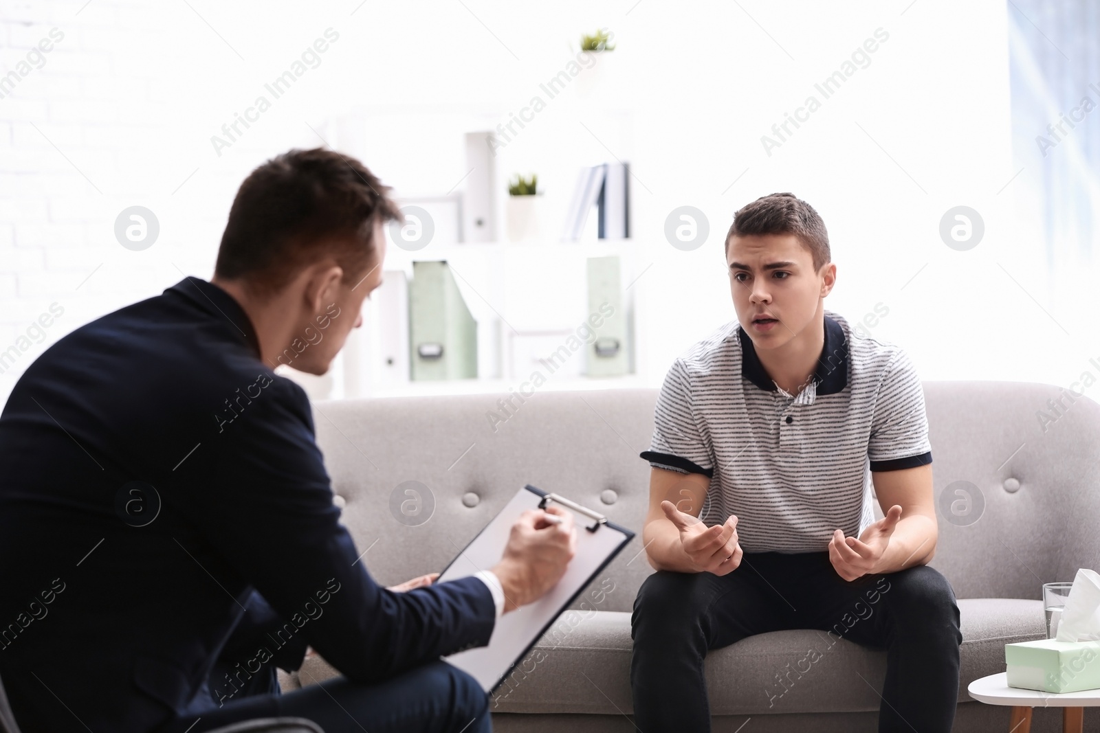 Photo of Psychotherapist working with young man in office