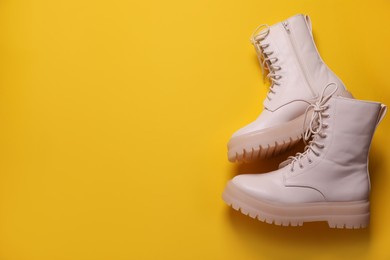 Pair of stylish shoes on yellow background, flat lay. Space for text