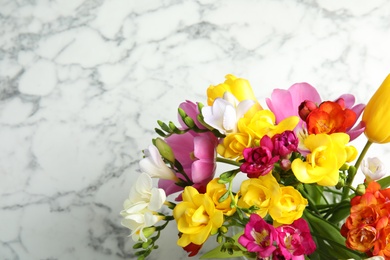 Photo of Beautiful spring freesia flowers on marble background, top view. Space for text