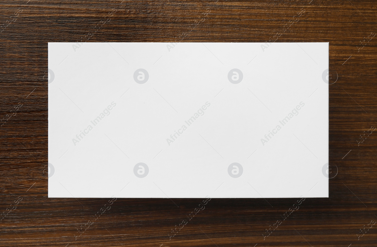 Photo of One blank business card on wooden table, top view. Mockup for design