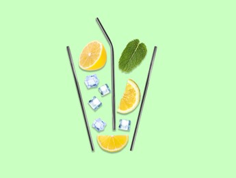 Image of Creative lemonade layout with lemon slices, mint, ice cubes and straws on color background, top view
