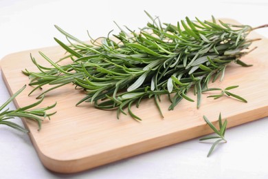Photo of Fresh green rosemary twigs on white wooden table, closeup
