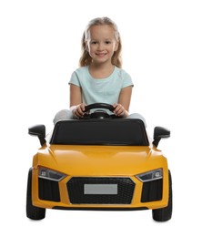 Photo of Cute little girl driving children's electric toy car on white background