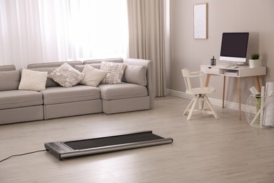 Modern walking treadmill in living room. Home gym equipment