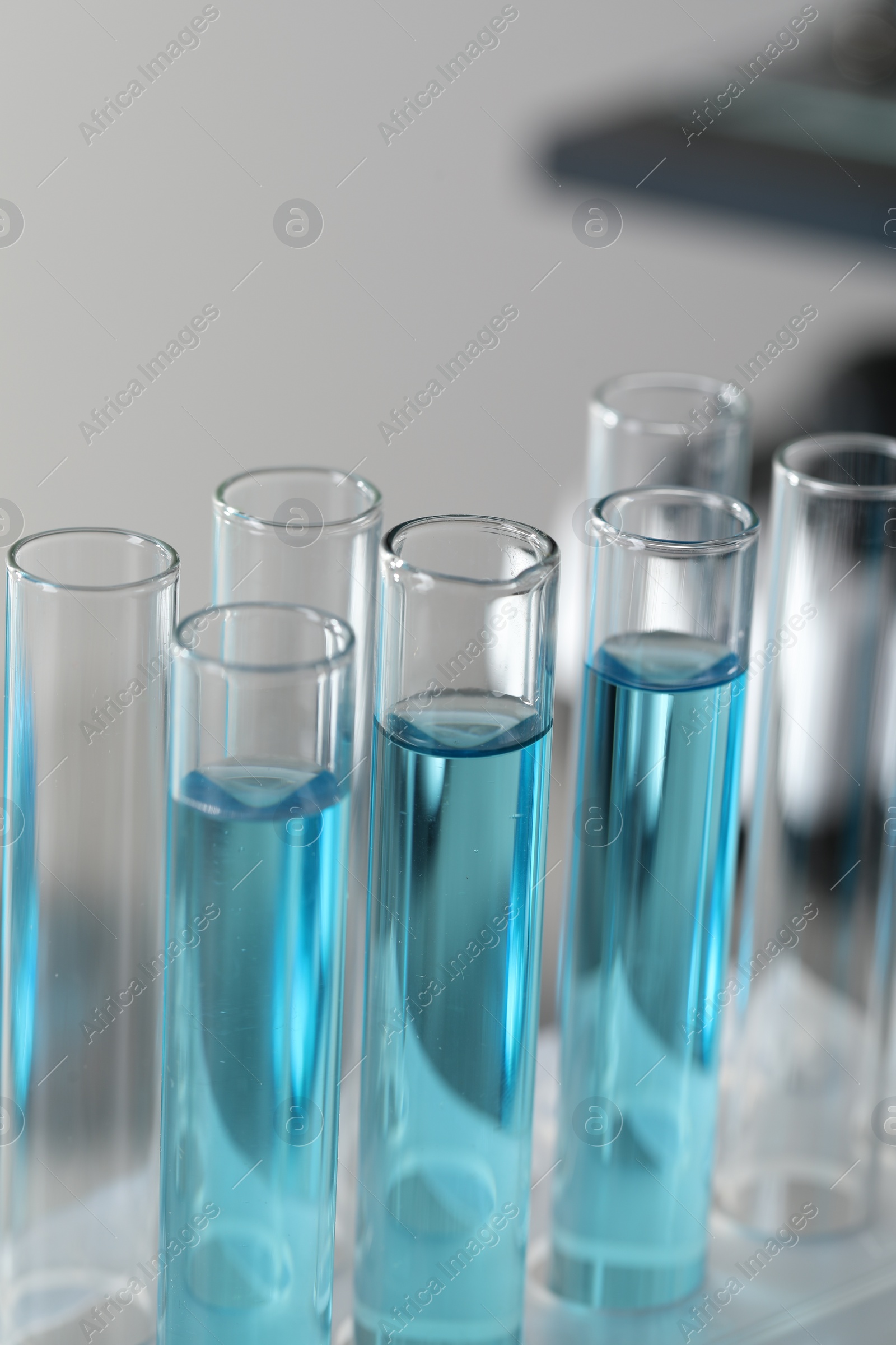 Photo of Test tubes with light blue liquid in laboratory, closeup