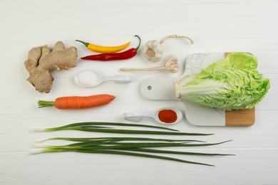 Photo of Flat lay composition with fresh Chinese cabbages and ingredients on white wooden table