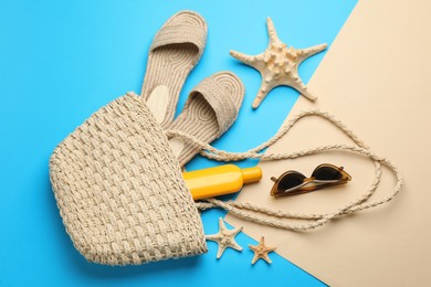 Stylish bag with beach accessories on color background, flat lay