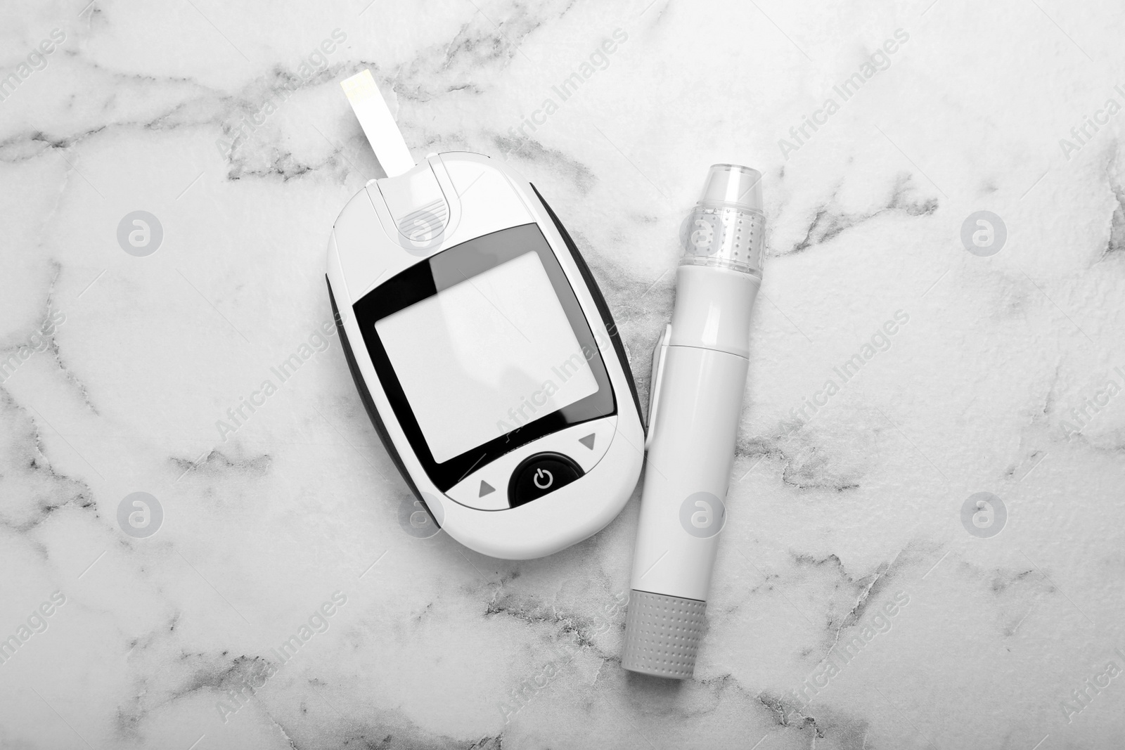 Photo of Glucometer and lancet pen on white marble table, flat lay. Diabetes testing kit