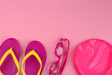 Photo of Flat lay composition with swimming accessories on pink background. Space for text