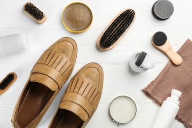 Photo of Flat lay composition with shoe care accessories and footwear on white wooden background