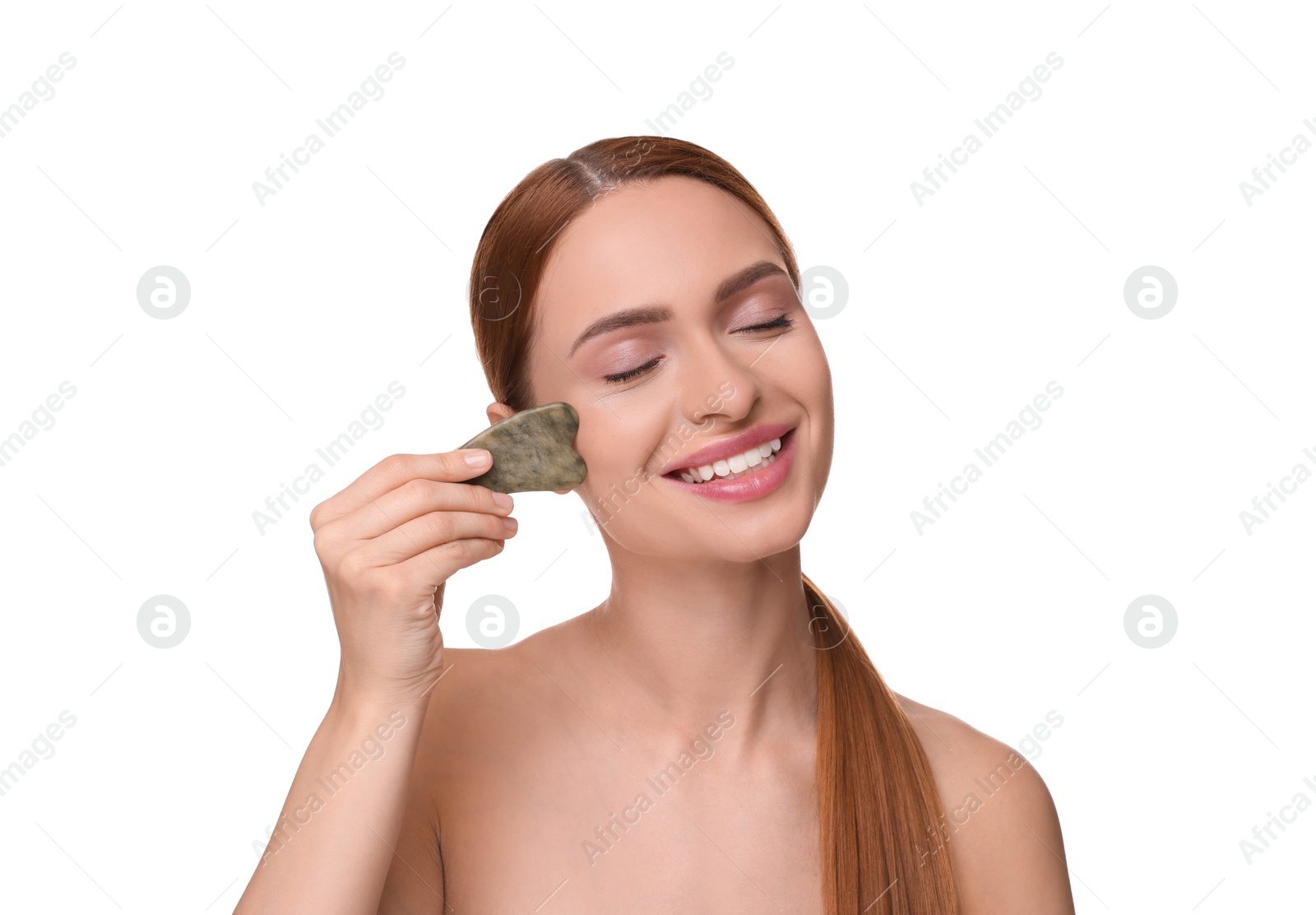 Photo of Young woman massaging her face with jade gua sha tool isolated on white