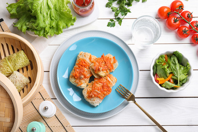 Photo of Delicious cabbage rolls served on white wooden table, flat lay