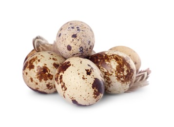 Photo of Speckled quail eggs and feathers isolated on white