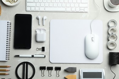 Photo of Flat lay composition with wired computer mouse and stationery on light grey table. Space for text