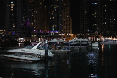 DUBAI, UNITED ARAB EMIRATES - NOVEMBER 03, 2018: Pier with luxury yachts at night