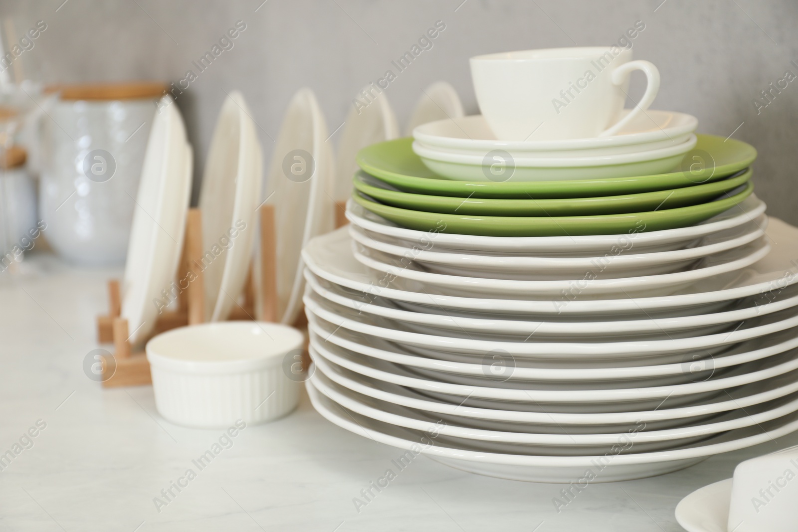 Photo of Clean plates, cup and bowl on white marble table