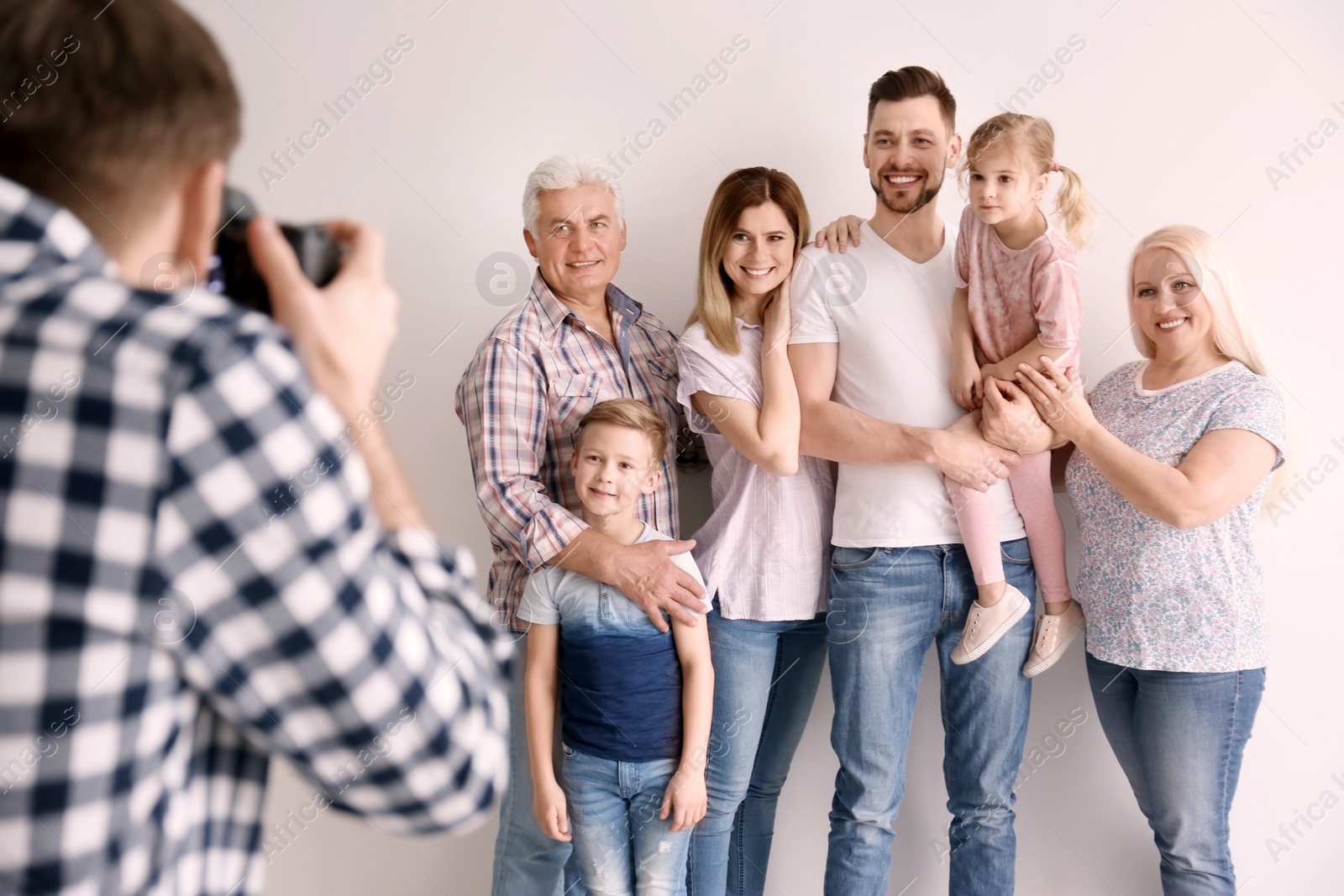 Photo of Professional photographer taking photo of family in studio