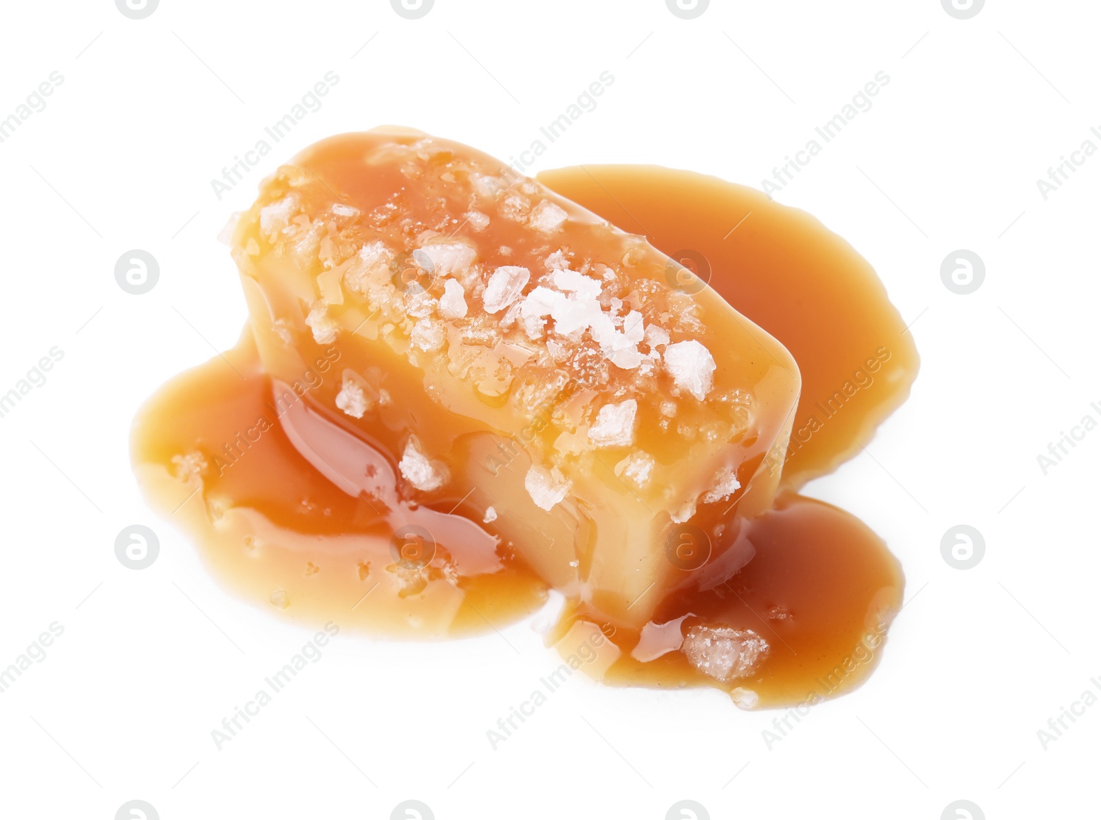 Photo of Yummy caramel candy and sea salt isolated on white