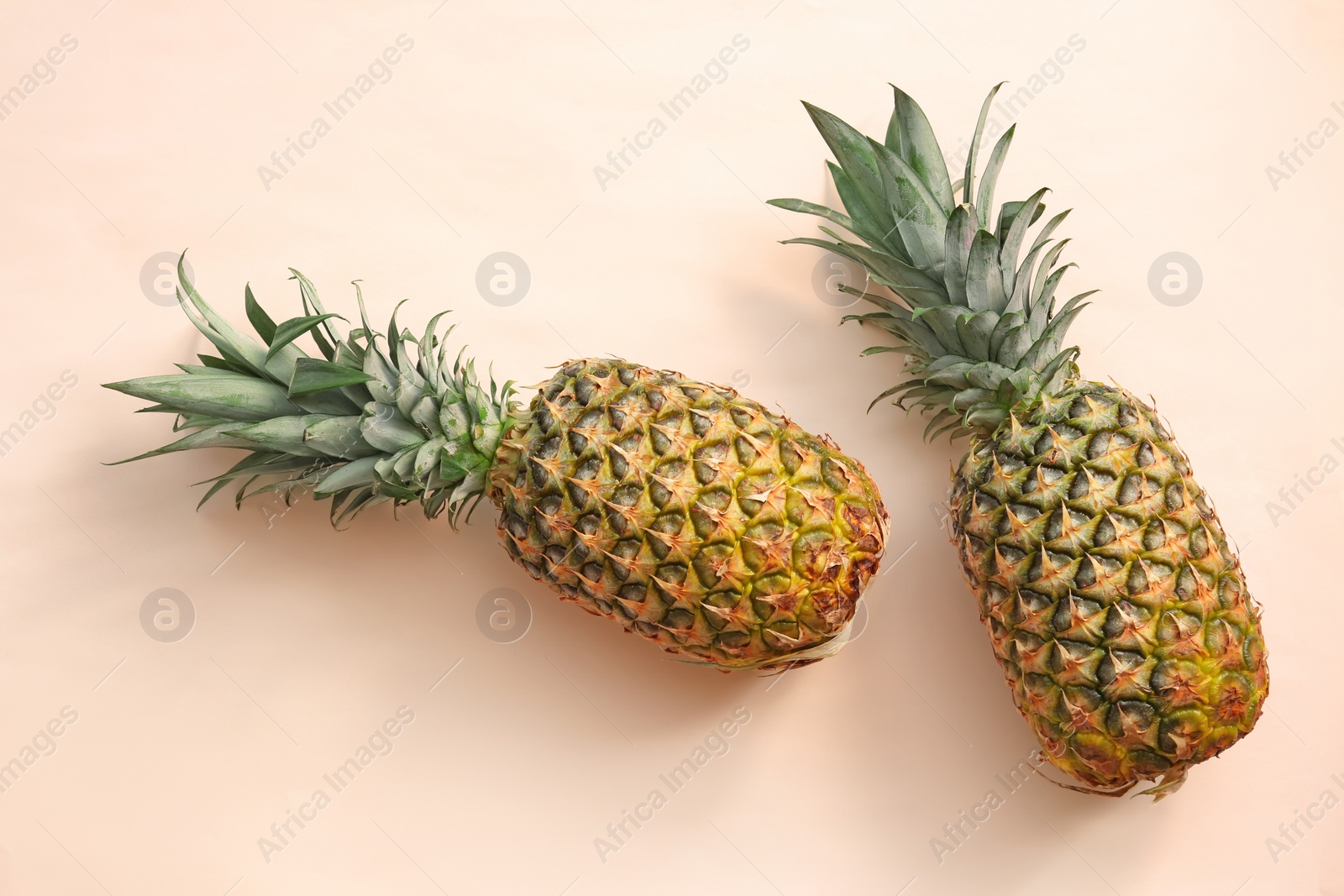 Photo of Fresh ripe pineapples on color background, top view