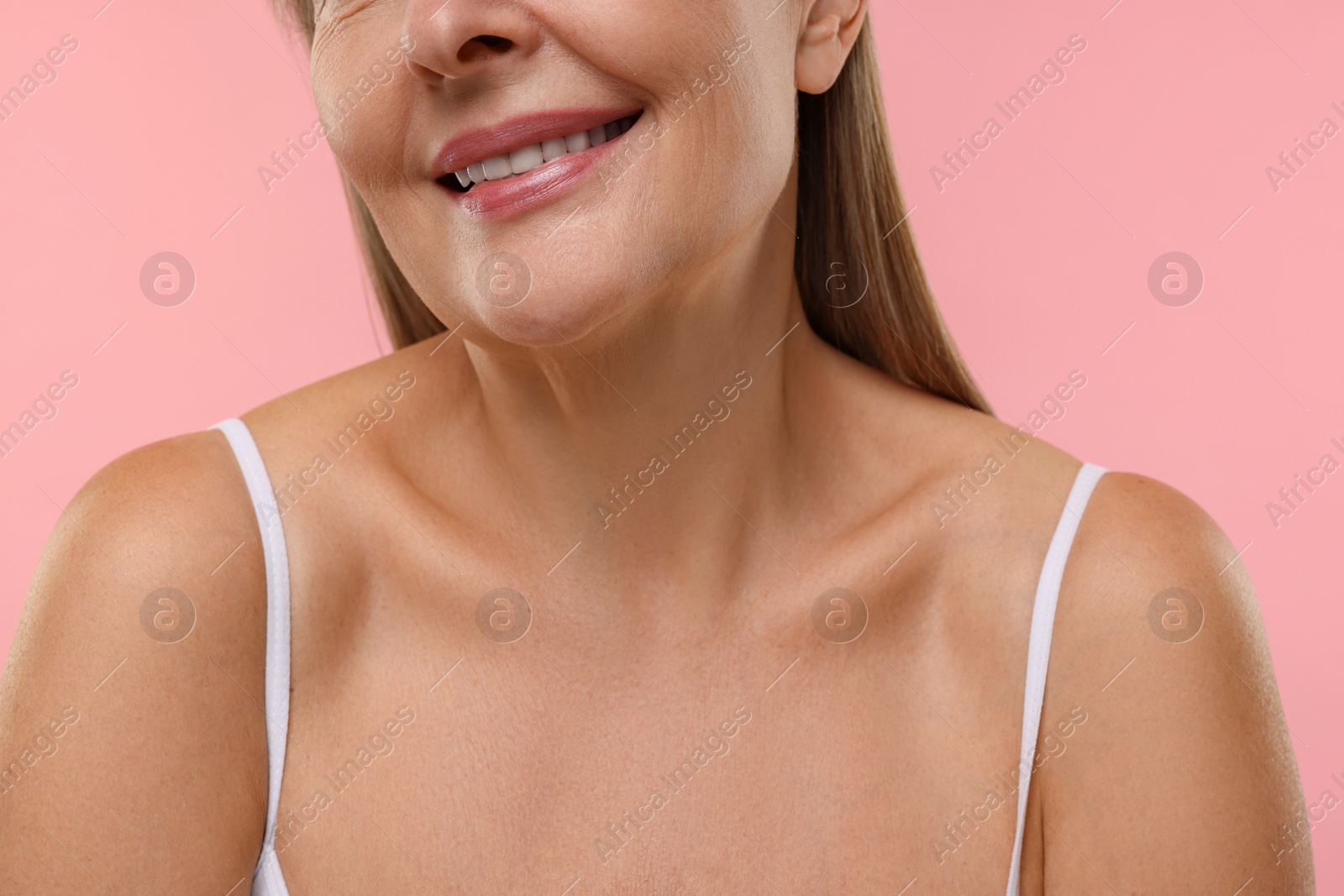 Photo of Mature woman with healthy skin on pink background, closeup