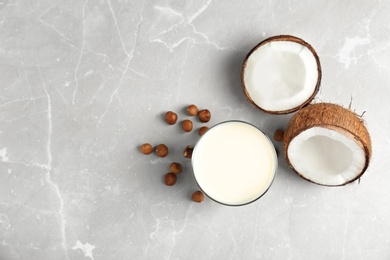 Glass with milk substitute and nuts on light background, top view