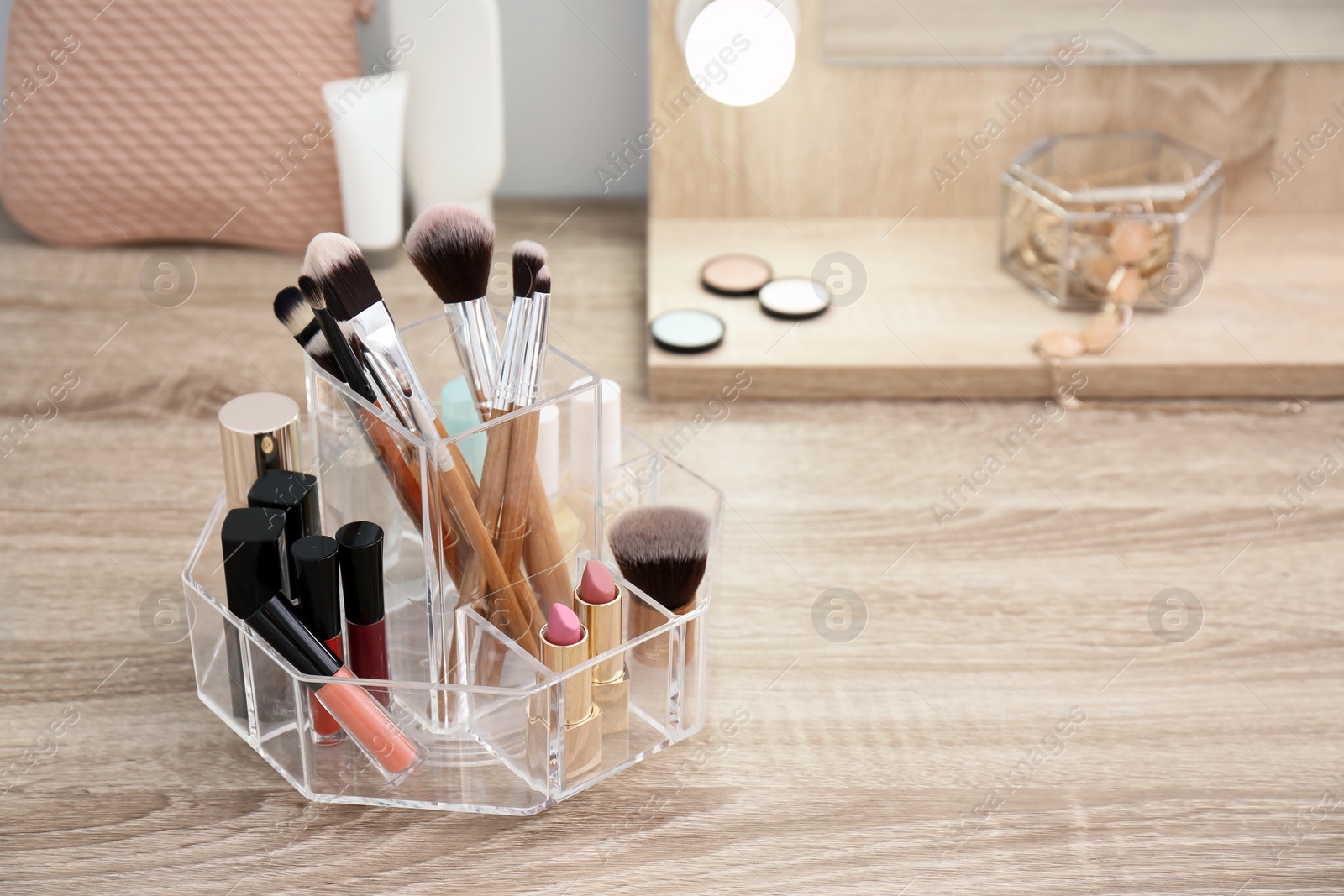 Photo of Organizer with cosmetic products for makeup on table. Space for text