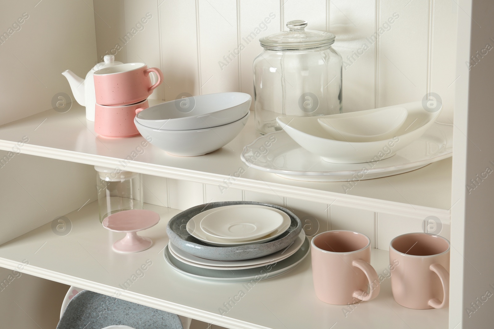 Photo of White shelving unit with set of dishware