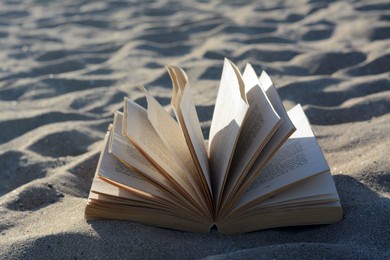 Open book on sandy beach, closeup view
