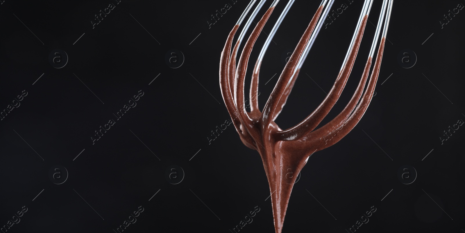 Image of Whisk with yummy chocolate cream on black background, closeup. Banner design with space for text