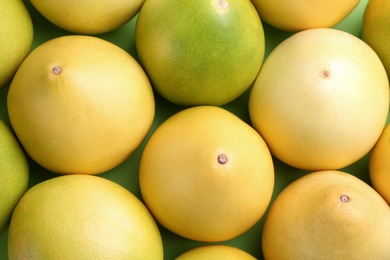 Photo of Fresh pomelo fruits on green background, flat lay