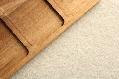 Photo of Wooden serving board on beige table, top view. Space for text