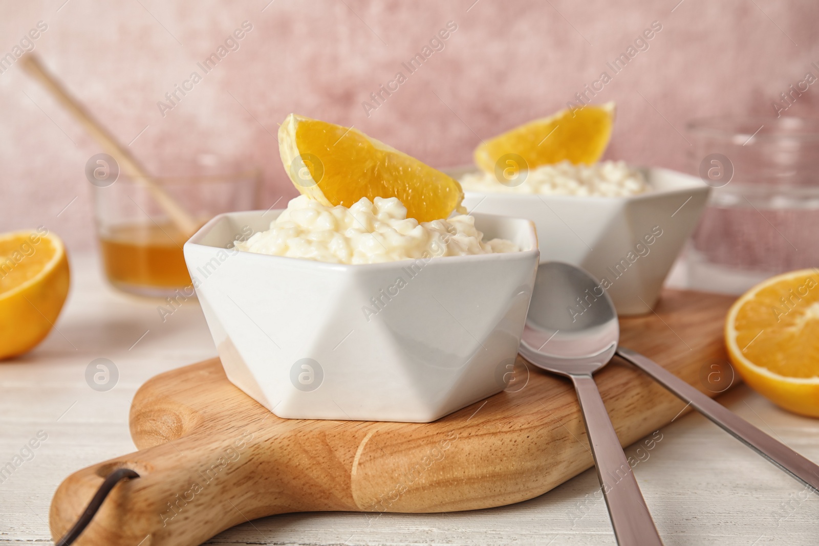 Photo of Creamy rice pudding with orange served on wooden table