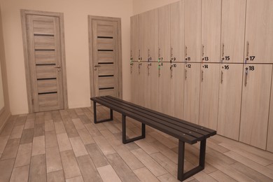 Wooden bench and lockers in changing room interior