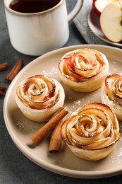 Photo of Freshly baked apple roses on grey table. Beautiful dessert