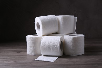 Photo of Soft toilet paper rolls on wooden table