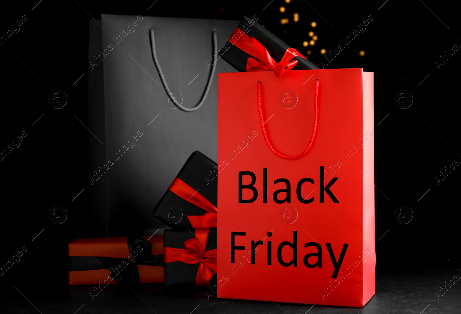 Photo of Paper shopping bags and gift boxes against blurred lights. Black Friday sale