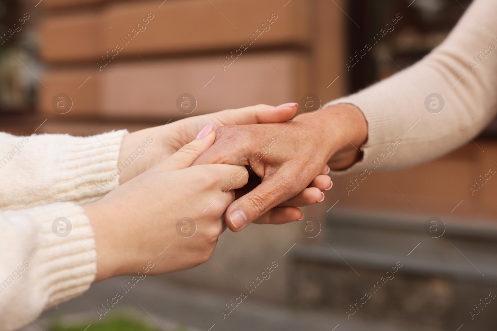 Photo of Trust and support. Women joining hands outdoors, closeup