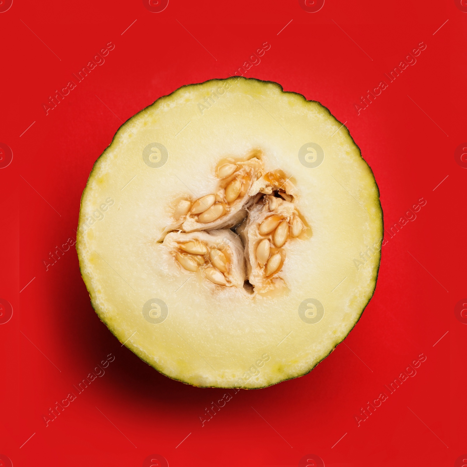 Photo of Half of ripe tasty melon on red background, top view