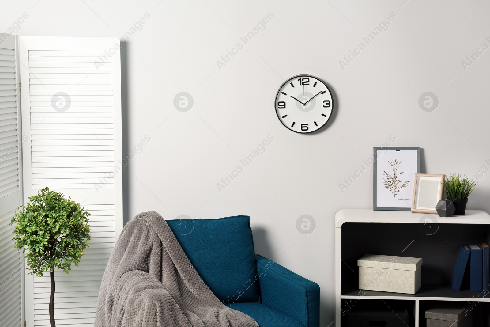 Photo of Room interior with clock on wall. Time management