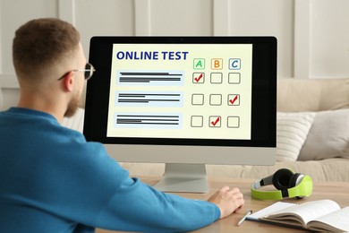 Man taking online test on computer at desk indoors