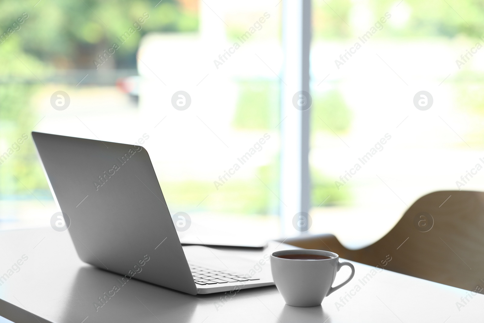 Photo of Comfortable workplace with modern laptop on desk in home office, space for text